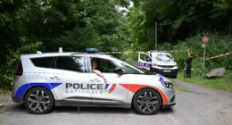Police cars are parked in front of a cordoned-off area, near a sports field where a 32-year-old man was found dead with his throat slit and gutted, in Pont-de-Metz on August 4, 2025. The victim had stab wounds to the neck and back and has been found by a walker in a cross position, police told AFP. (Photo by Francois NASCIMBENI / AFP) (Photo by FRANCOIS NASCIMBENI/AFP via Getty Images)