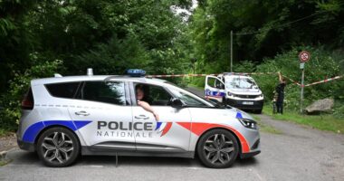 Police cars are parked in front of a cordoned-off area, near a sports field where a 32-year-old man was found dead with his throat slit and gutted, in Pont-de-Metz on August 4, 2025. The victim had stab wounds to the neck and back and has been found by a walker in a cross position, police told AFP. (Photo by Francois NASCIMBENI / AFP) (Photo by FRANCOIS NASCIMBENI/AFP via Getty Images)