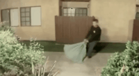 Doorbell camera footage of a man dragging a large sack.