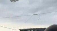Pedal boat lifted by a tornado over a beach.