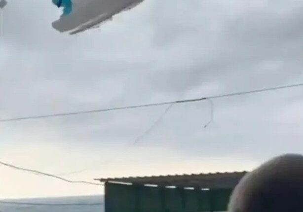 Pedal boat lifted by a tornado over a beach.