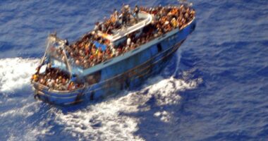 Overcrowded migrant boat at sea.