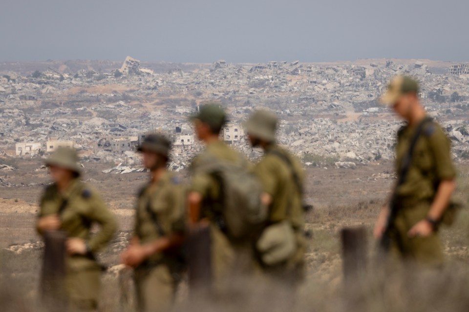 Israeli soldiers observing destroyed buildings in the Gaza Strip.