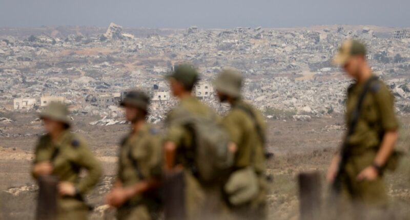 Israeli soldiers observing destroyed buildings in the Gaza Strip.