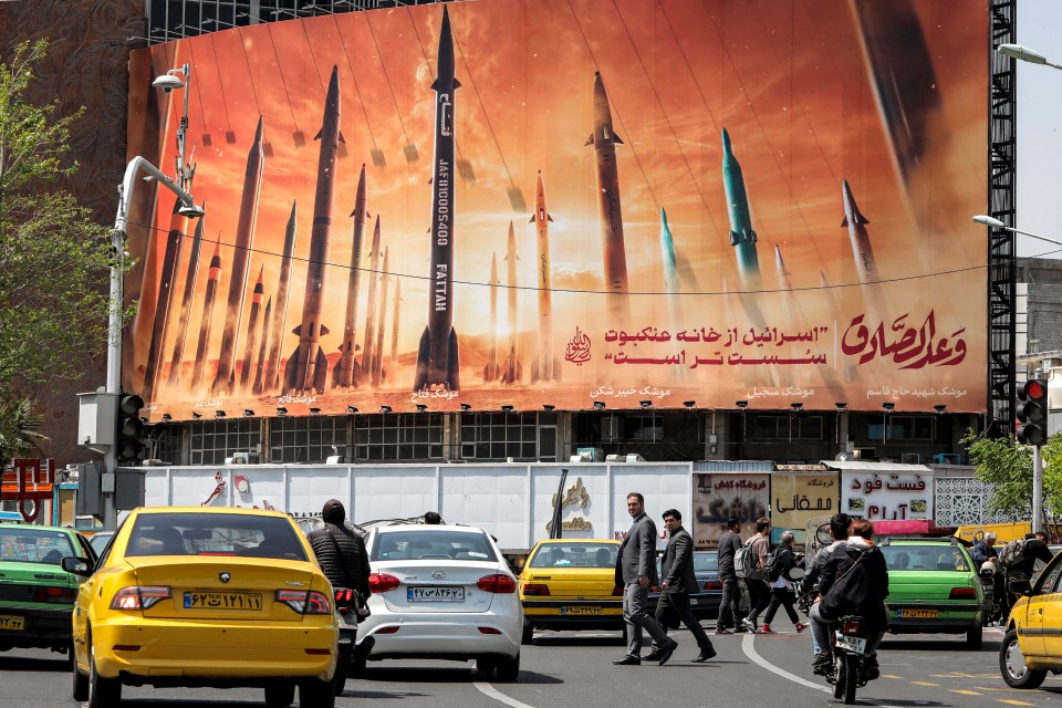 Billboard depicting Iranian ballistic missiles; text reads "Israel is weaker than a spider's web".