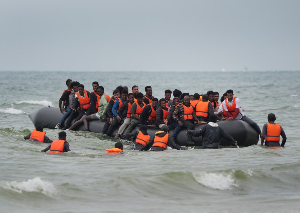Migrants in a small boat at sea.