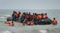 Migrants in a small boat at sea.