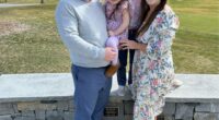 Family photo of four people in front of a stone wall.