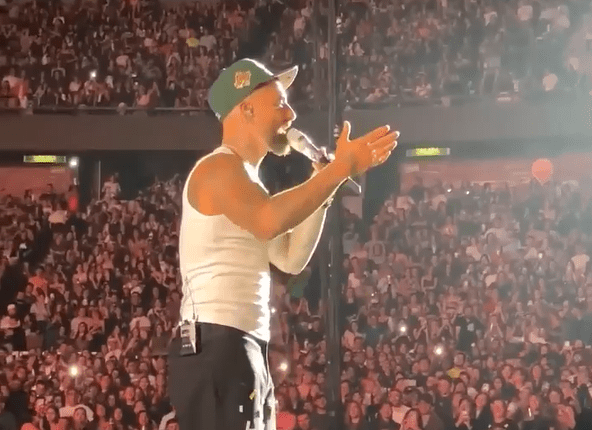 Singer performing on stage in front of a large crowd.