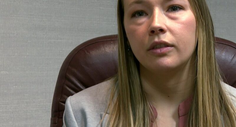 Woman in gray jacket giving interview.