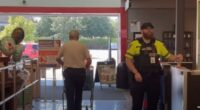 Security guard checking receipts at store exit.