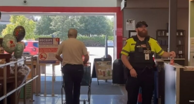 Security guard checking receipts at store exit.