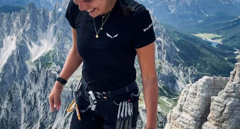 Woman smiling on a mountain summit.