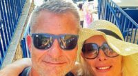 Selfie of a couple on vacation, overlooking a beach.