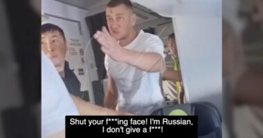 A man on an airplane yelling at another passenger.
