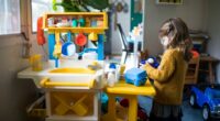 A little girl playing with a toy kitchen.