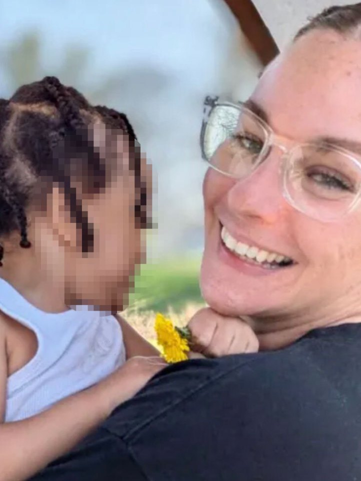 Photo of a smiling woman holding a toddler.