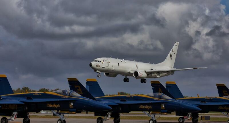 Boeing P-8 Poseidon flying over Blue Angels jets.