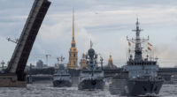 Three Russian warships sailing past a raised drawbridge in St. Petersburg.