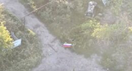 Aerial view of Russian soldiers with a flag in Yablunivka, Ukraine.