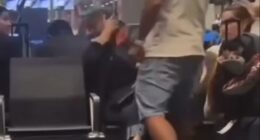 A man slapping a woman in an airport terminal.