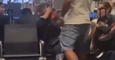 A man slapping a woman in an airport terminal.