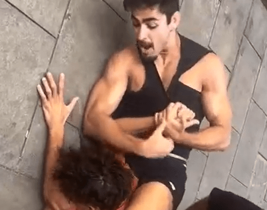 Man holding another man in a wrestling hold.