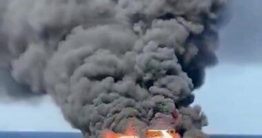 Burning yacht sinking in the ocean.