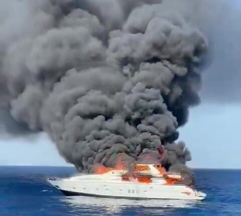 Burning yacht sinking in the ocean.