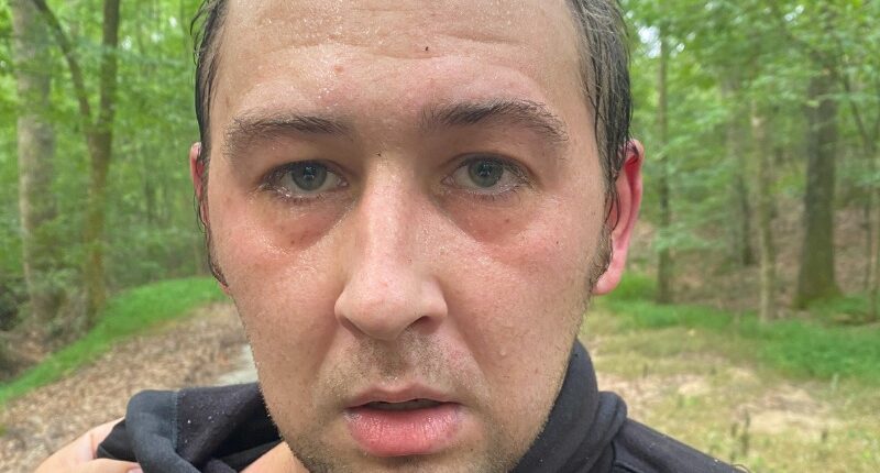 Photo of a sweaty man in a dark hoodie, with a Tennessee Bureau of Investigation logo.