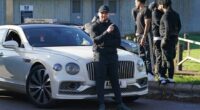 Man released from prison posing by a white Bentley.