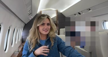 Woman sitting in a private jet, holding a drink.