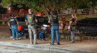 FBI, ATF, and U.S. Park Police officers assisting a woman experiencing apparent synthetic marijuana side effects.