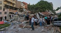 People removing debris from a collapsed building after an earthquake.