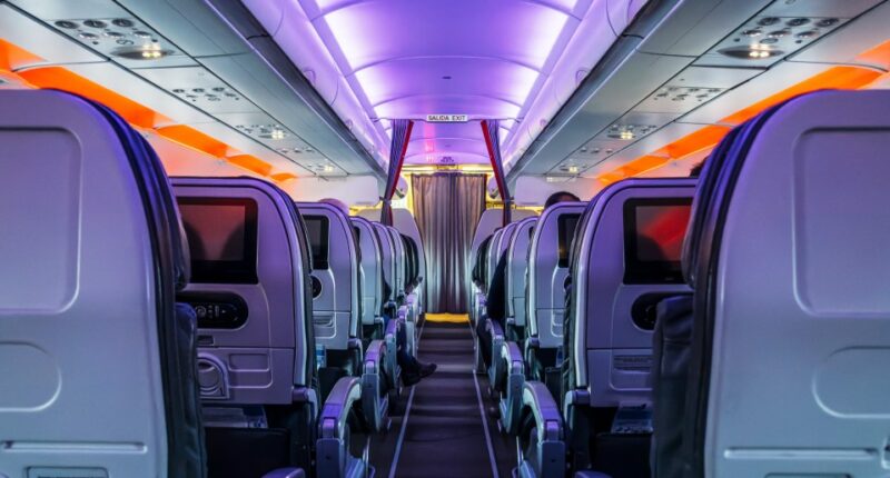 Airplane passenger cabin aisle at night.