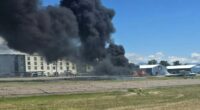 Plane crash with large plume of black smoke.