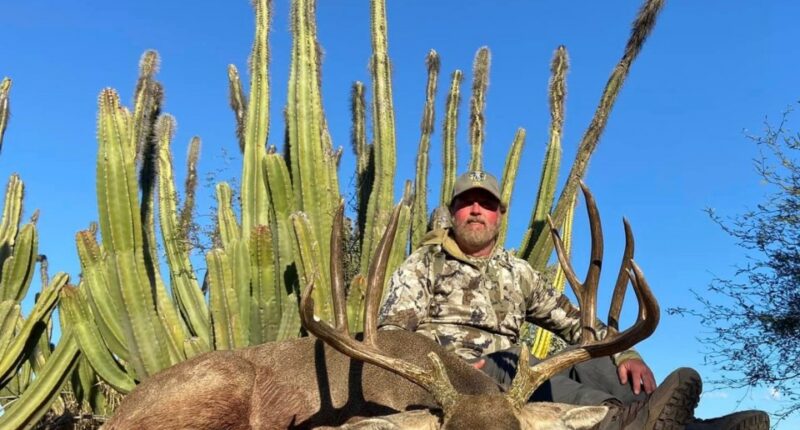 Hunter posing with a large desert mule deer.
