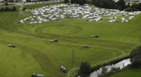 Aerial view of numerous caravans parked in a field.