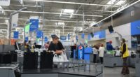 Customers using self-checkout kiosks in a Walmart.