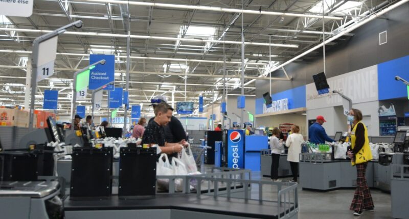 Customers using self-checkout kiosks in a Walmart.