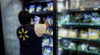 Walmart employee stocking frozen vegetables.