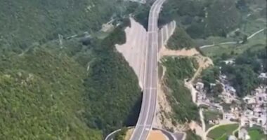 Aerial view of a highway cut through a mountain in China.