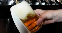 A bartender pours a craft beer.