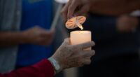 Vigil attendees light candles after Annunciation Catholic School shooting