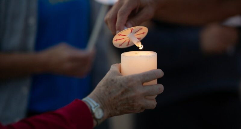 Vigil attendees light candles after Annunciation Catholic School shooting