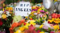 A sign reading "RIP Angels" sits amid flowers at a memorial at Annunciation Catholic Church