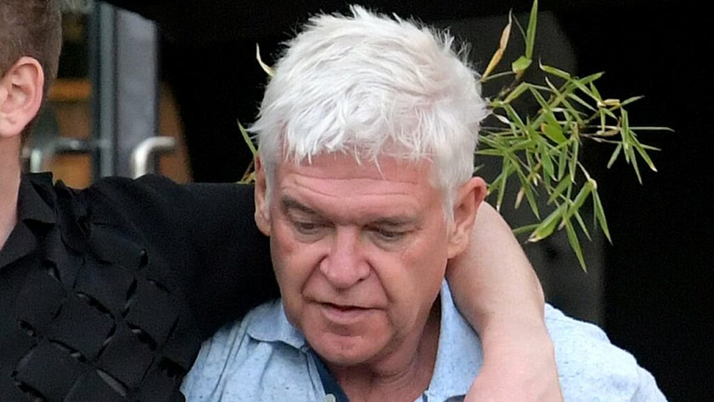 Phillip Schofield, 63, stumbles out of a bar with a 30-year-old male companion in London... while carefree Holly Willoughby lives it up in Portugal