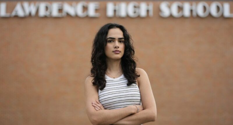 Natasha Torkzaban stands outside Lawrence High School, where she and other students have filed a lawsuit against the school district's use of digital surveillance software, Sunday, Aug. 3, 2025, in Lawrence, Kan. (AP Photo/Charlie Riedel)