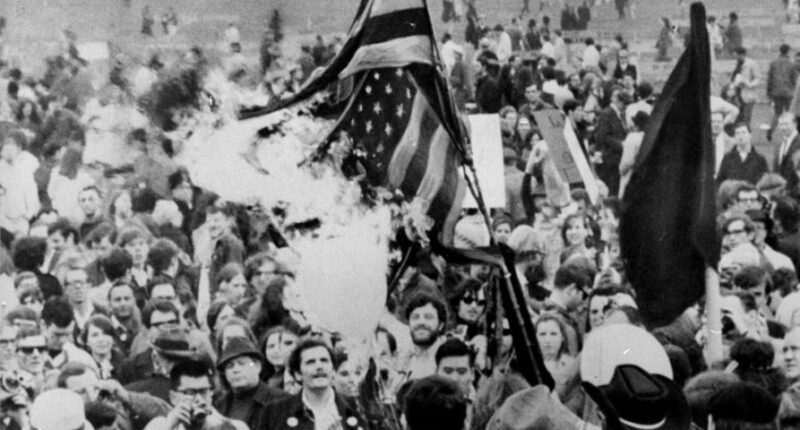 APRIL 15, 1967: An American flag burns in the Sheep Meadow of Central Park as peace marchers warm to the task of marching to the UN in protest of the war in Vietnam. A crowd estimated at 125,000 marched through midtown for the "Spring Mobilization Against the War in Vietnam." (Photo by Leonard Detrick/NY Daily News Archive via Getty Images)