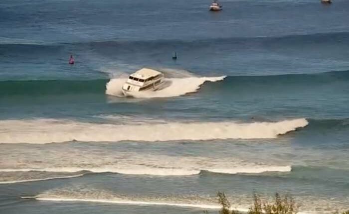 Yacht-sized passenger boat runs aground in high surf off Hawaii beach